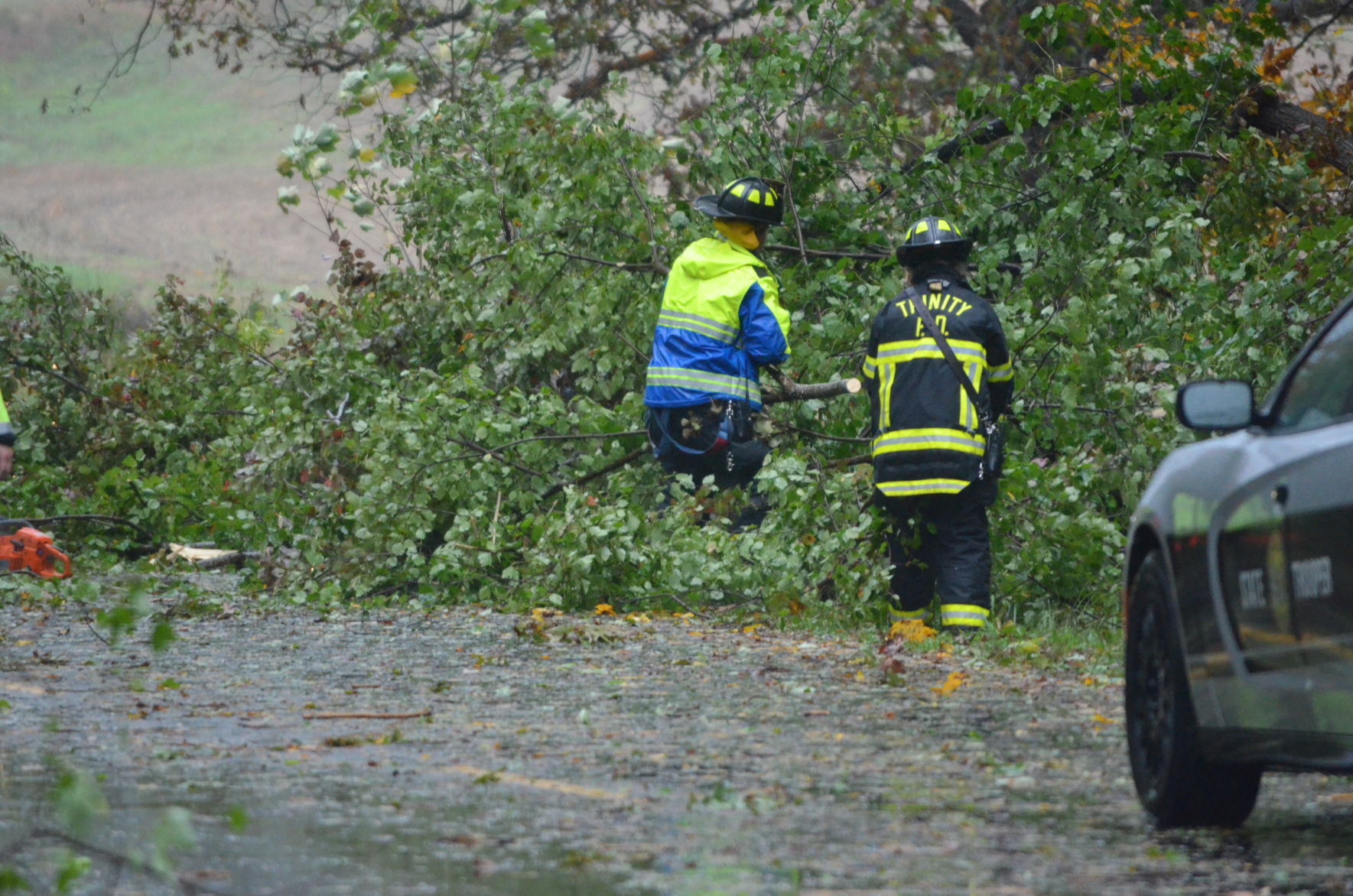 Members of the Trinity Fire Department cut apart a tree that fell near Wilkesboro Highway on Thursday as the remnants of Hurricane Zeta came through Statesville.
